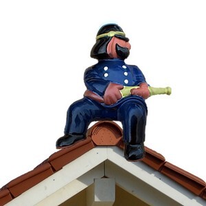 feuerwehrmann, sitzend mit spritze auf einem firstziegel, traditionell glasiert mit dachziegelglasuren