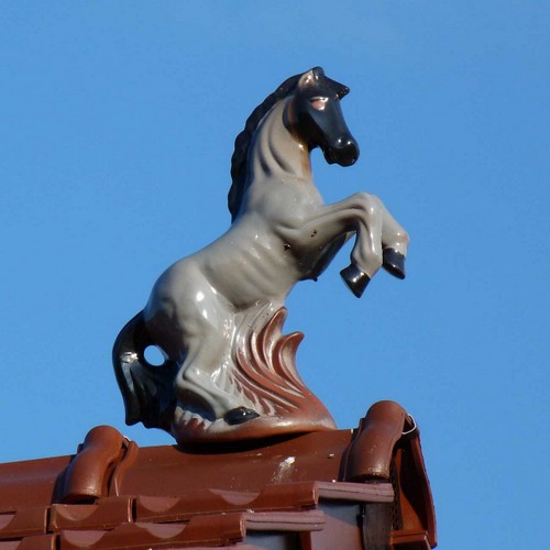steigendes pferd aus ton braun glasiert mit mähne und ausschweifenden schwanz