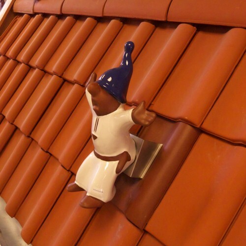 montage, dachschmuck-dachrutscher aus ton mit edelstahlschuh auf einem flächenziegel montage, dachrutscher als schlafwandler mit edelstahlschuh auf einem flächenziegel