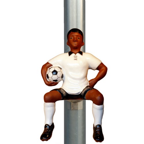 fussballer als fallrohrfigur fussballer sitzend mit fussball