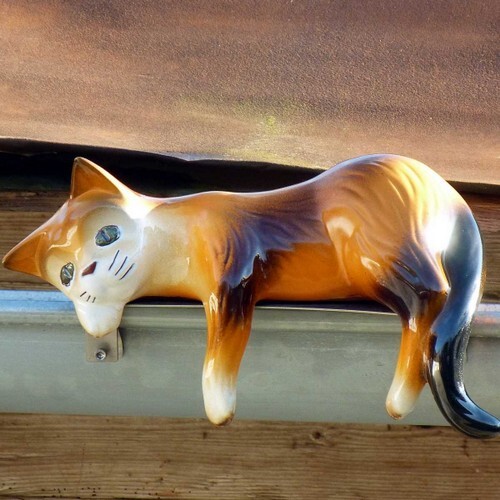 rinnenkatze liegend mit edelstahlhalterung auf einer dachrinne, glasiert in verschiedenen farben